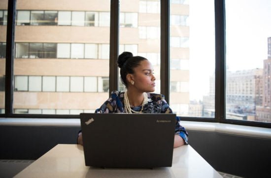 a woman with a laptop sitting in an offie