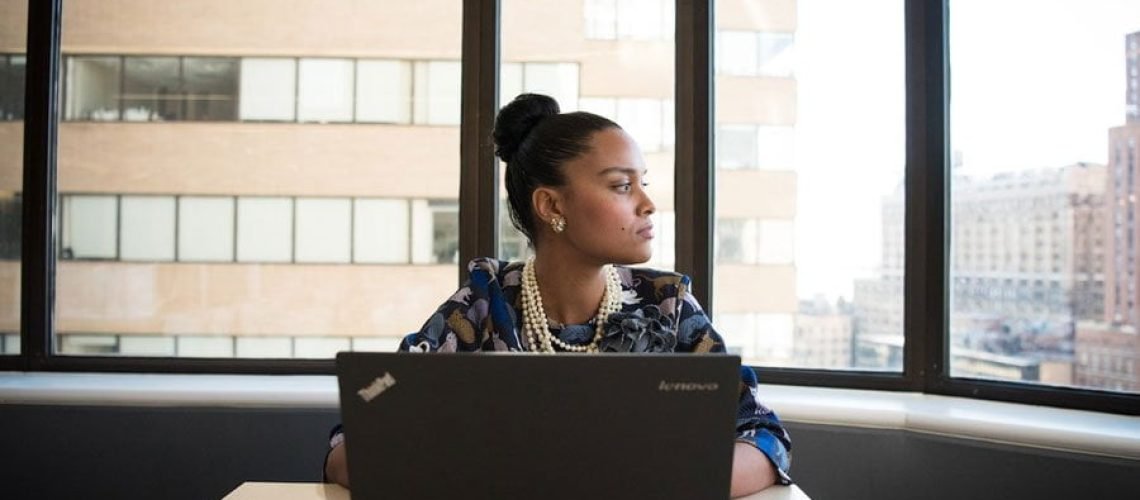 a woman with a laptop sitting in an offie